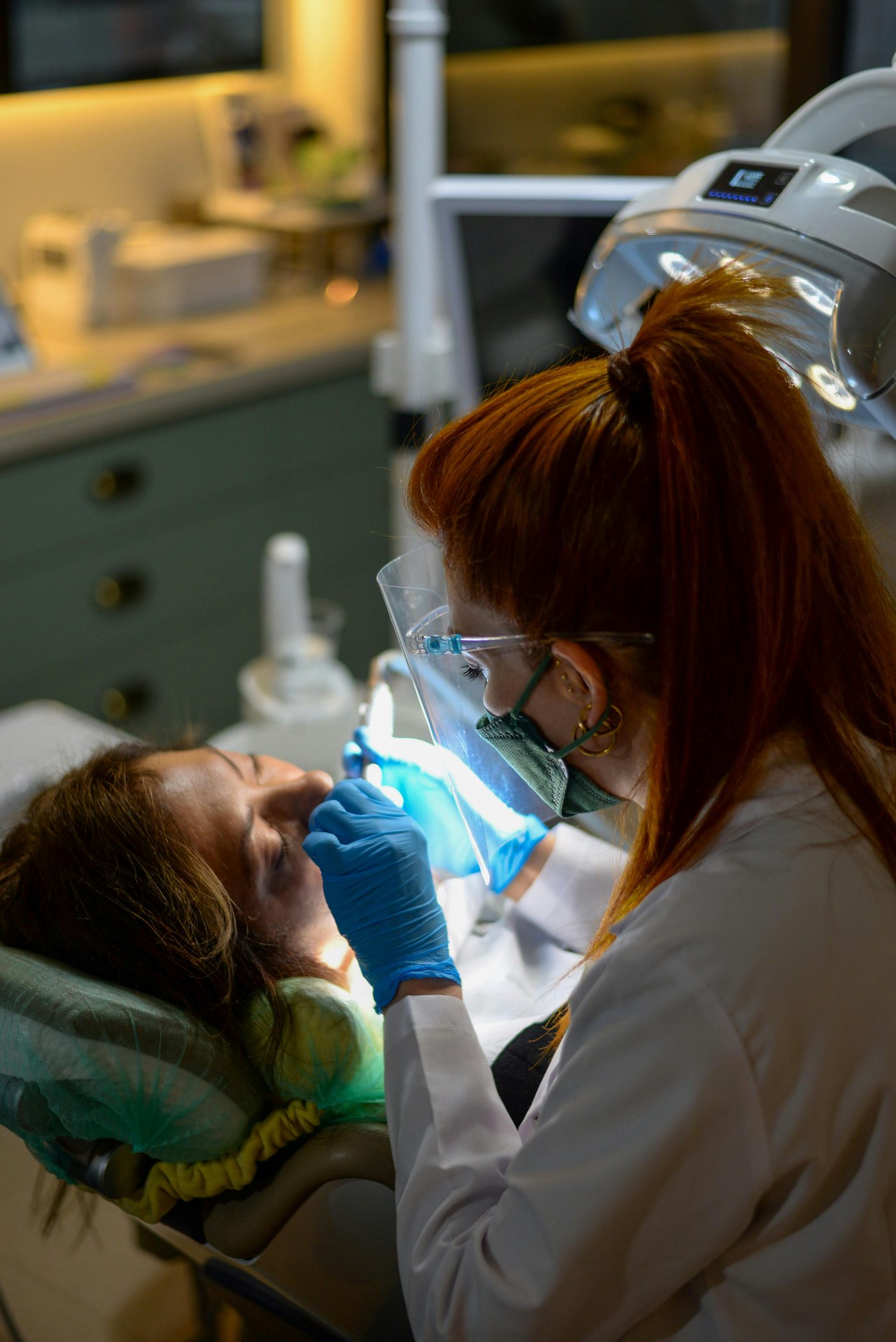 Dentist showing a patient her smile in a hand mirror at Queens Dental Practice